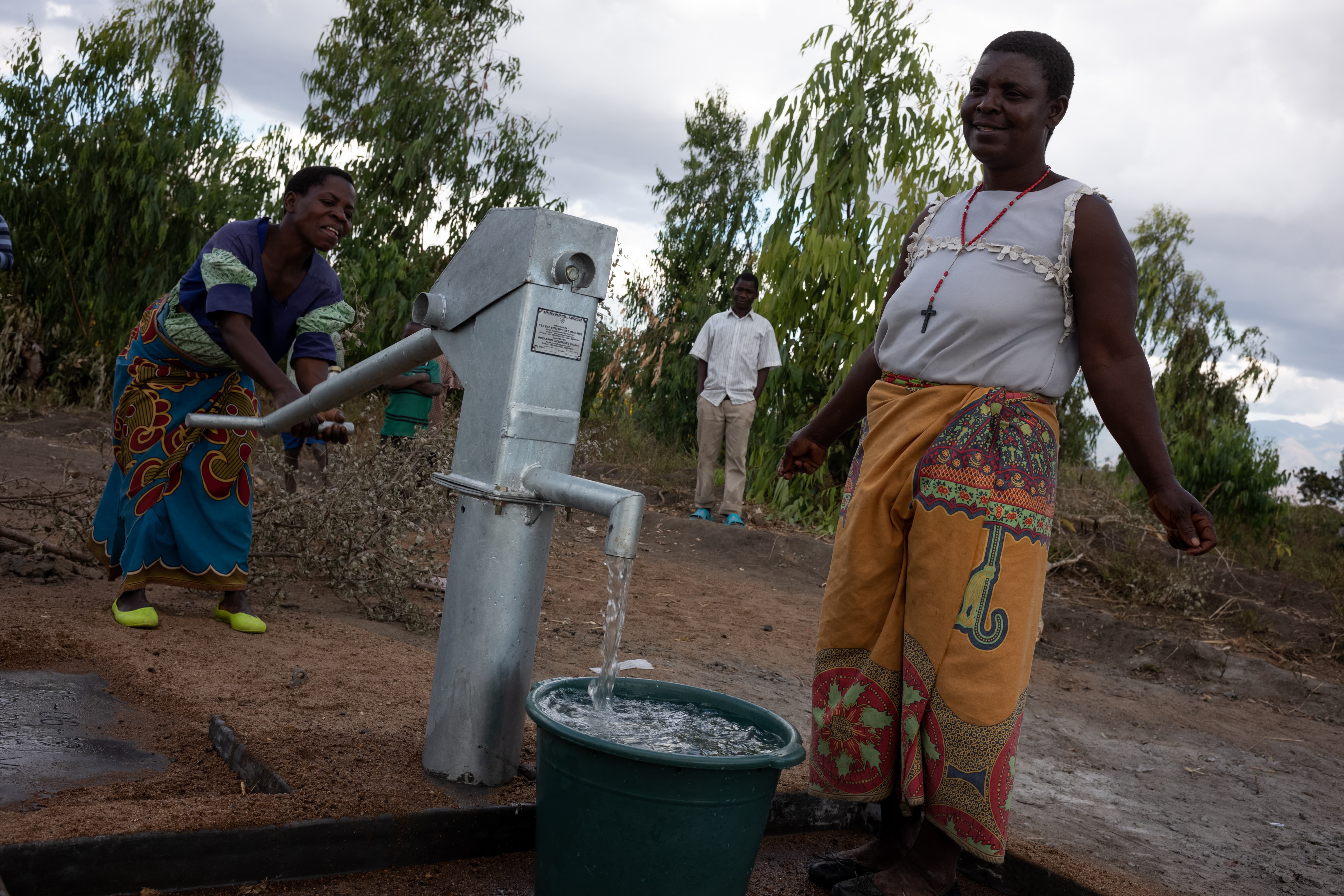 Mary Gawani (left), 32, and Mary Kamanga (right), 51, collecting water at a borehole constructed by Oxfam in Gwembere Village, Phalombe District, southern Malawi. (Photo: Ko Chung Ming / Oxfam Volunteer Photographer)